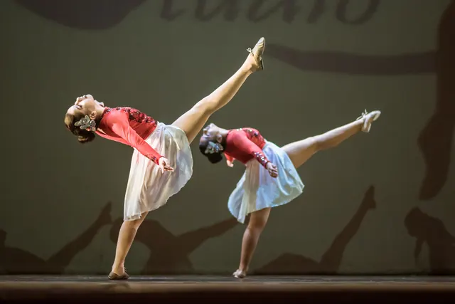 Dos bailarinas con blusa roja y falda blanca ejecutando el mismo movimiento en EDC 2019.
